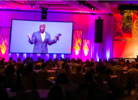 wide angle photo of Eric Boles during a keynote address with a large audience The Game Changers Inc coaching keynoting training